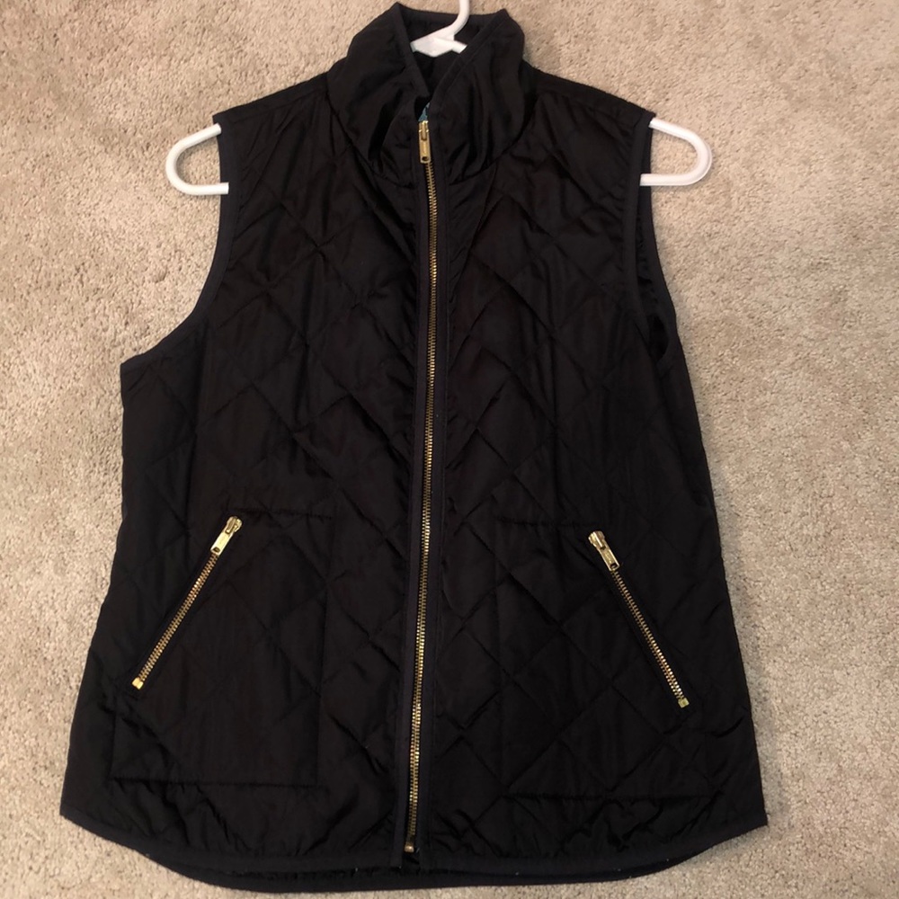 Black vest with gold zippers.